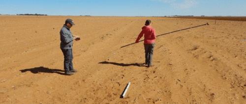 two researchers on a dry field