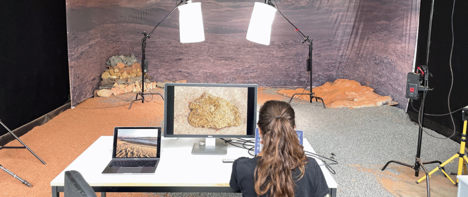 Forscherin sitzt vor künstlicher Marslandschaft
